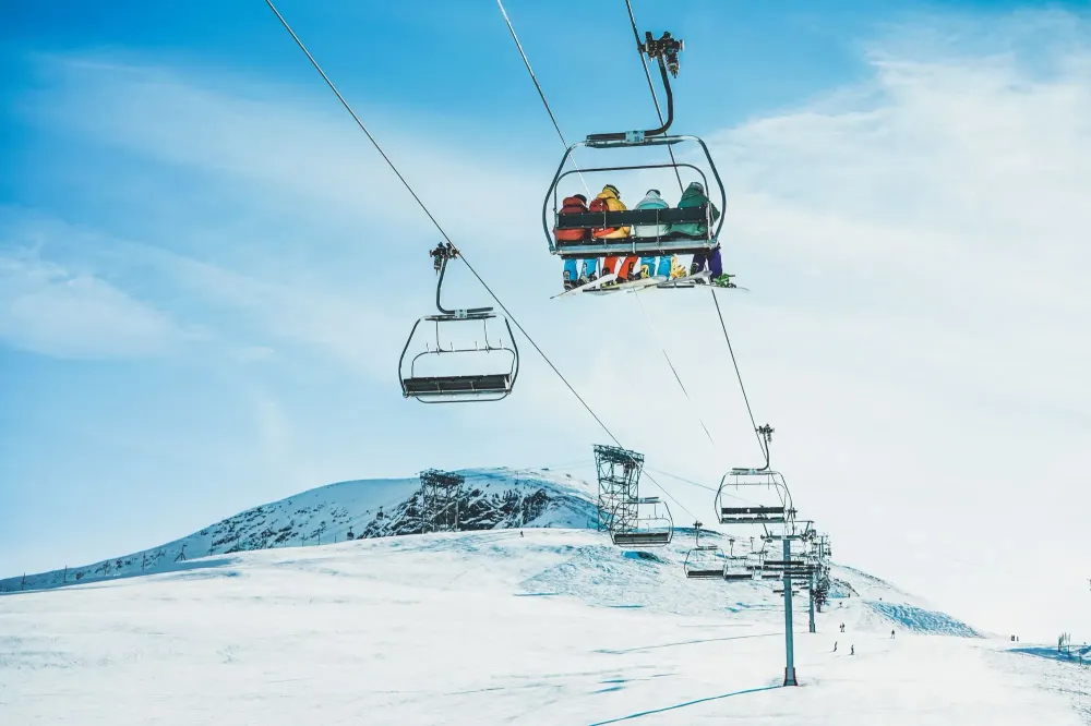 People on ski lift going up snowy mountain